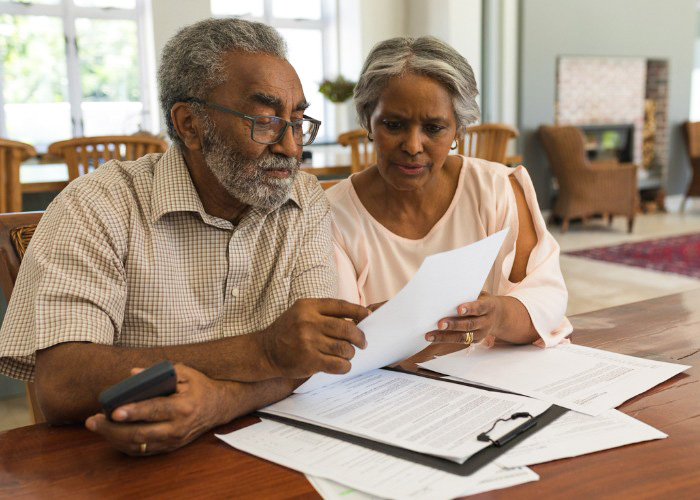 senior couple reviewing paper invoices at home