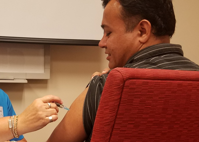 two people, nurse giving man a flu shot