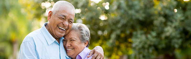 Smiling senior couple hugging at a park