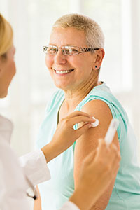 senior woman smiling after receiving a vaccination from a nurse