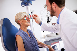 2 people, ophthalmologist giving patient eye exam